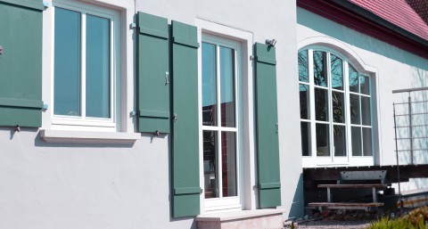 Großes Holzfenster mit schmalem Rahmen und moderner Verglasung, eingebaut in einem Wohnraum mit Blick nach draußen