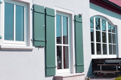 Großes Holzfenster mit schmalem Rahmen und moderner Verglasung, eingebaut in einem Wohnraum mit Blick nach draußen