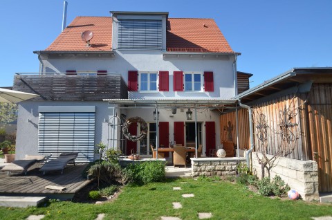 Umgebautes Haus mit neuen weißen Fenstern, Alu-Fensterläden, Sonnenschutz-Jalousien